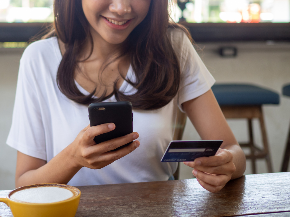 Woman at a Coffee Shop using Credit Card to Pay