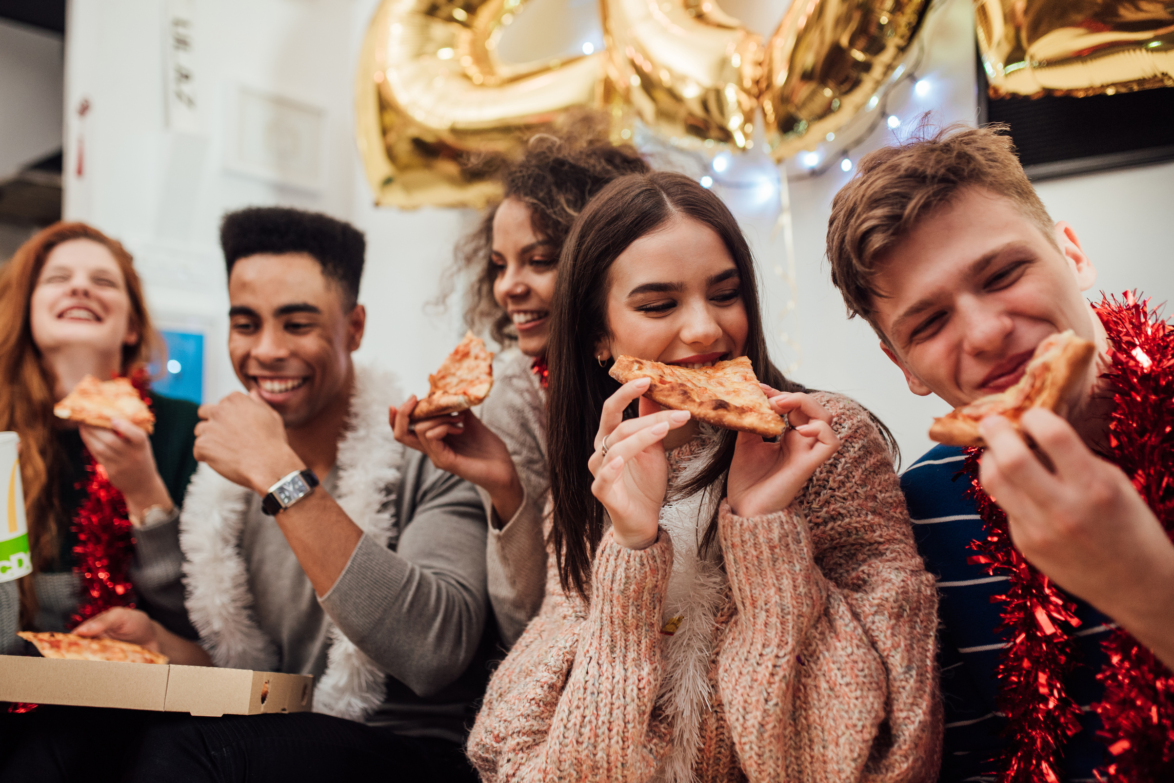 Smiling people eating pizza